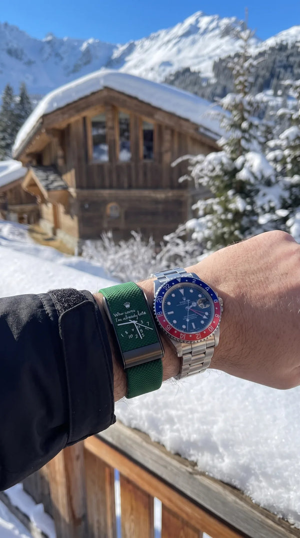 QUIETUDE Already Late band in Forest worn on the forearm in front of a snow-covered chalet